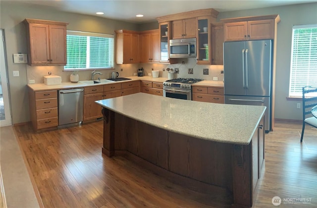 3328 Pennsylvania, Longview, WA 98632 - kitchen with appliances with stainless steel finishes, light wood-style floors, glass insert cabinets, recessed lighting, and a kitchen island