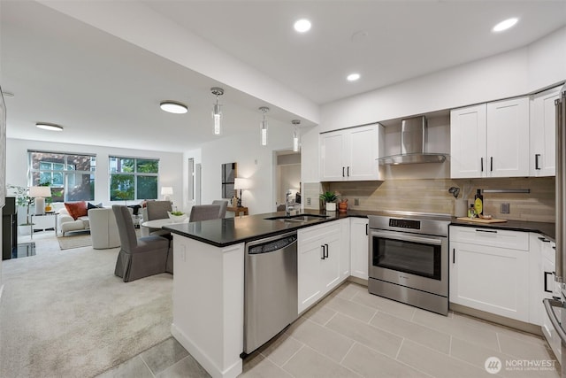 5450 Leary Ave NW Unit 251, Seattle, WA 98107 - kitchen with stainless steel appliances, wall chimney exhaust hood, a peninsula, open floor plan, and white cabinets