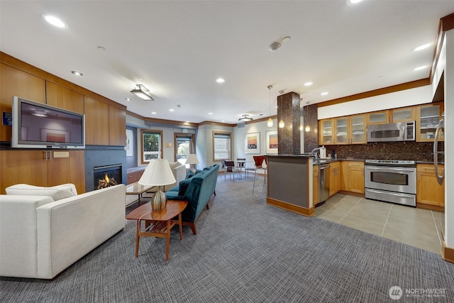 5450 Leary Ave NW Unit 251, Seattle, WA 98107 - kitchen with stainless steel appliances, open floor plan, a peninsula, glass insert cabinets, and a glass covered fireplace