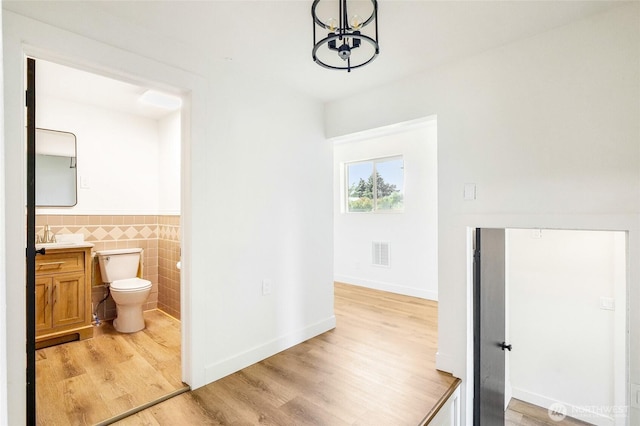 449 NE Cliff Ave, Wilbur, WA 99185 - bathroom featuring vanity, tile walls, a chandelier, toilet, and wood finished floors