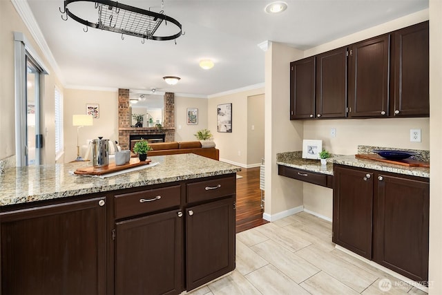 600 213th St SW, Bothell, WA 98021 - kitchen featuring crown molding, dark brown cabinetry, open floor plan, and light stone countertops
