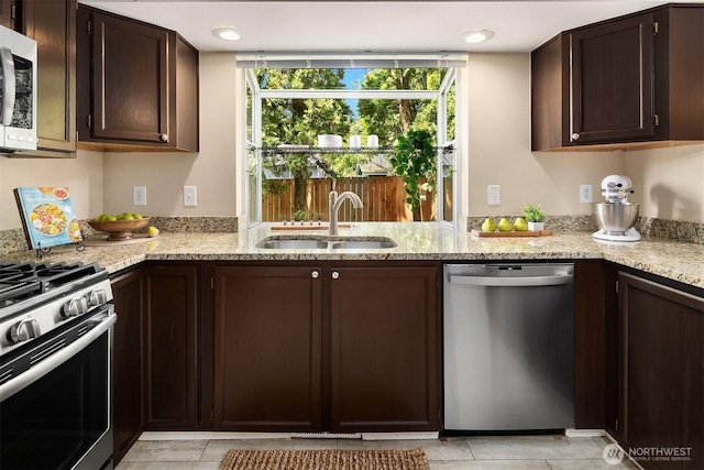 600 213th St SW, Bothell, WA 98021 - kitchen with appliances with stainless steel finishes, dark brown cabinetry, light tile patterned floors, and light stone countertops