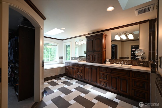804 S Park Ct, Lynden, WA 98264 - full bath with a chandelier, a skylight, double vanity, a walk in closet, and ornamental molding