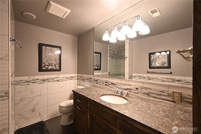 804 S Park Ct, Lynden, WA 98264 - full bath featuring tiled shower, vanity, tile walls, tile patterned flooring, and a wainscoted wall