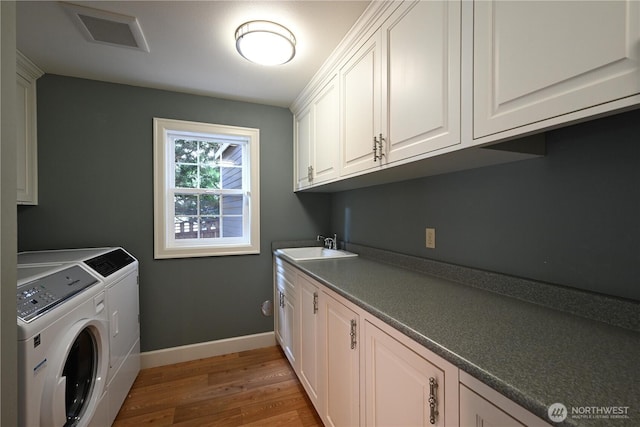 804 S Park Ct, Lynden, WA 98264 - laundry area featuring washer and clothes dryer, light wood-type flooring, and cabinet space
