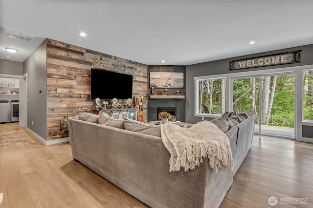 17501 Clearlake Blvd SE, Yelm, WA 98597 - living area featuring independent washer and dryer, a large fireplace, light wood finished floors, and recessed lighting