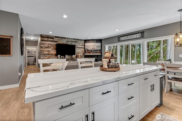 17501 Clearlake Blvd SE, Yelm, WA 98597 - kitchen featuring light stone counters, white cabinetry, hanging light fixtures, light wood finished floors, and recessed lighting