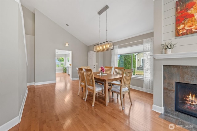 7114 Hazel Pl SE, Auburn, WA 98092 - dining space featuring a tile fireplace, hardwood / wood-style floors, high vaulted ceiling, and a chandelier
