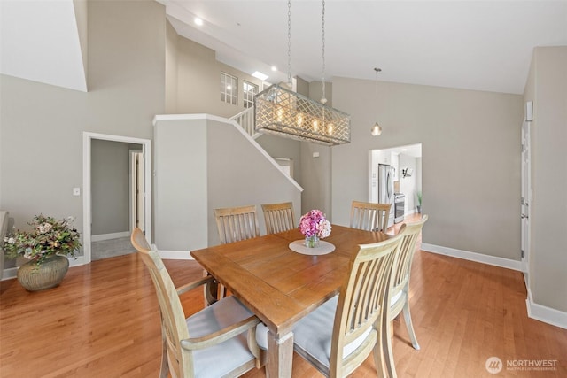 7114 Hazel Pl SE, Auburn, WA 98092 - dining space featuring high vaulted ceiling, light wood-style floors, and stairs