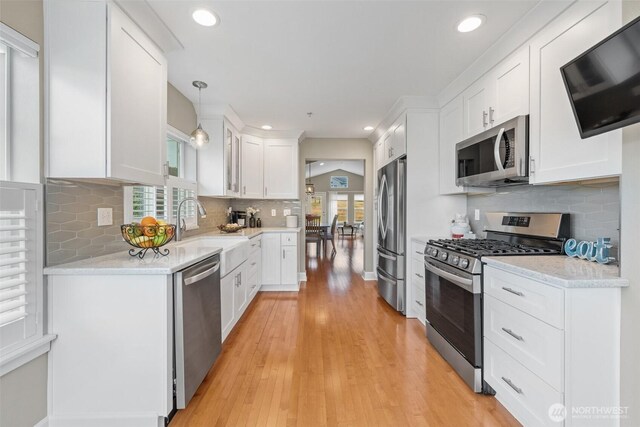 7114 Hazel Pl SE, Auburn, WA 98092 - kitchen with appliances with stainless steel finishes, white cabinets, backsplash, light wood-style flooring, and recessed lighting