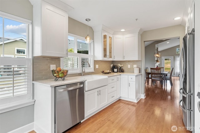 7114 Hazel Pl SE, Auburn, WA 98092 - kitchen with stainless steel appliances, white cabinets, tasteful backsplash, decorative light fixtures, and glass insert cabinets