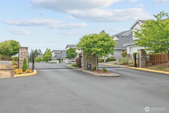 7114 Hazel Pl SE, Auburn, WA 98092 - view of asphalt road with a gate, a gated entry, curbs, and a residential view