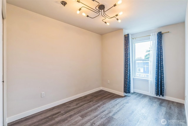 1124 S 23rd St, Tacoma, WA 98405 - spare room featuring a chandelier, dark wood finished floors, and baseboards