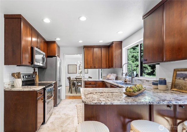 15052 253rd Ave SE, Issaquah, WA 98027 - kitchen with appliances with stainless steel finishes, light stone countertops, a peninsula, recessed lighting, and a breakfast bar