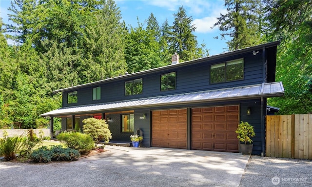 15052 253rd Ave SE, Issaquah, WA 98027 - view of front of home featuring asphalt driveway, a chimney, covered porch, a metal roof, and a standing seam roof