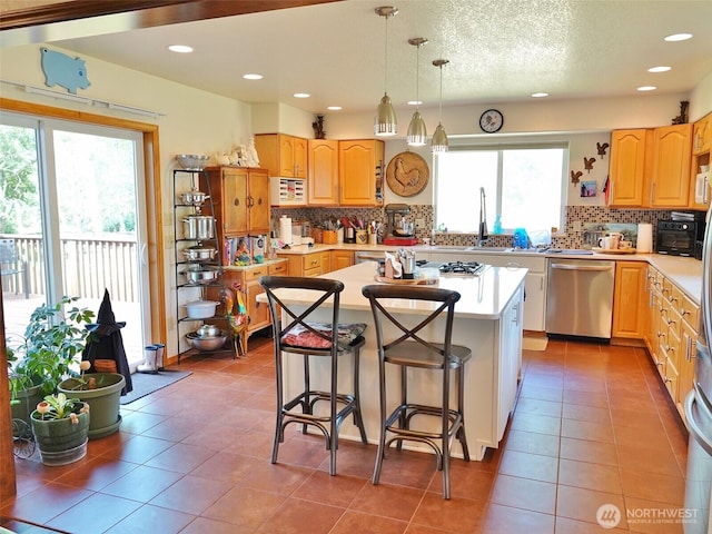 801 Hassalo Ave SE, Ocean Shores, WA 98569 - kitchen featuring appliances with stainless steel finishes, a center island, light countertops, decorative backsplash, and recessed lighting