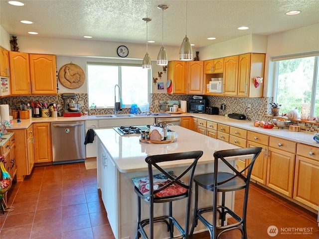 801 Hassalo Ave SE, Ocean Shores, WA 98569 - kitchen with stainless steel dishwasher, white microwave, a kitchen breakfast bar, gas cooktop, and a textured ceiling