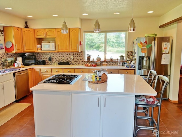 801 Hassalo Ave SE, Ocean Shores, WA 98569 - kitchen featuring stainless steel appliances, backsplash, dark tile patterned floors, light countertops, and recessed lighting