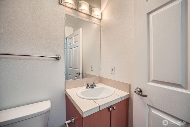 621 5th Ave N Unit 306, Seattle, WA 98109 - bathroom featuring vanity, toilet, and a textured wall