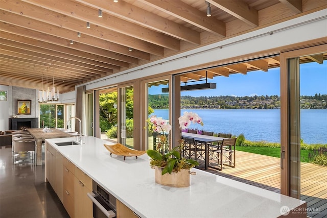 7964 E Mercer Way, Mercer Island, WA 98040 - kitchen featuring a water view, plenty of natural light, beam ceiling, a sink, and open floor plan