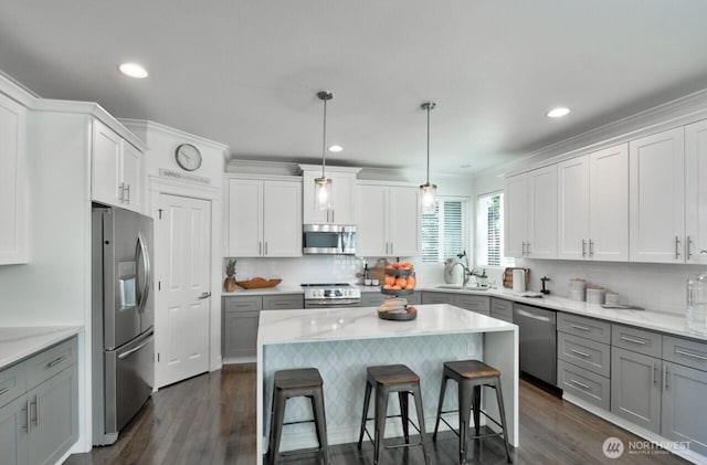 4704 204th Ct E, Spanaway, WA 98387 - kitchen with stainless steel appliances, gray cabinets, a kitchen bar, dark wood-style flooring, and recessed lighting