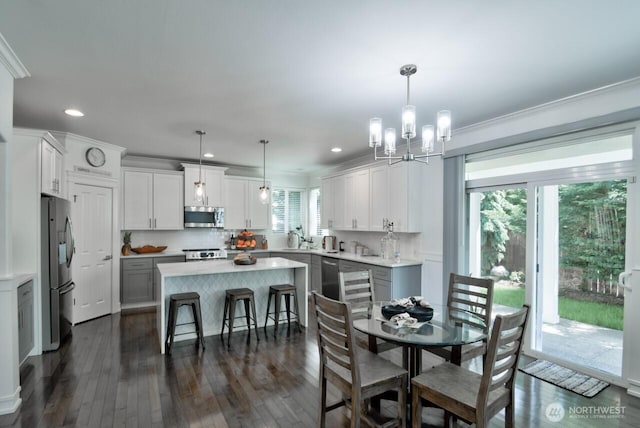 4704 204th Ct E, Spanaway, WA 98387 - dining space featuring a chandelier, dark wood-style flooring, ornamental molding, and recessed lighting