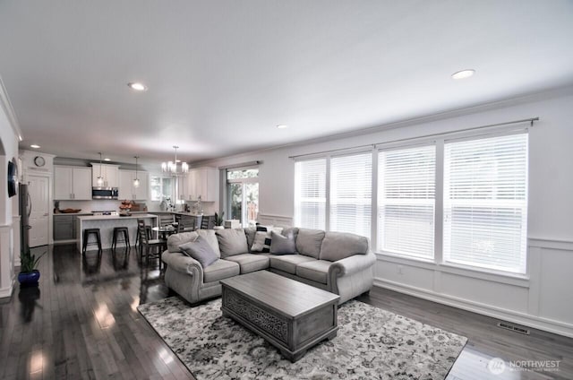 4704 204th Ct E, Spanaway, WA 98387 - living room featuring crown molding, dark wood-style floors, a chandelier, and recessed lighting