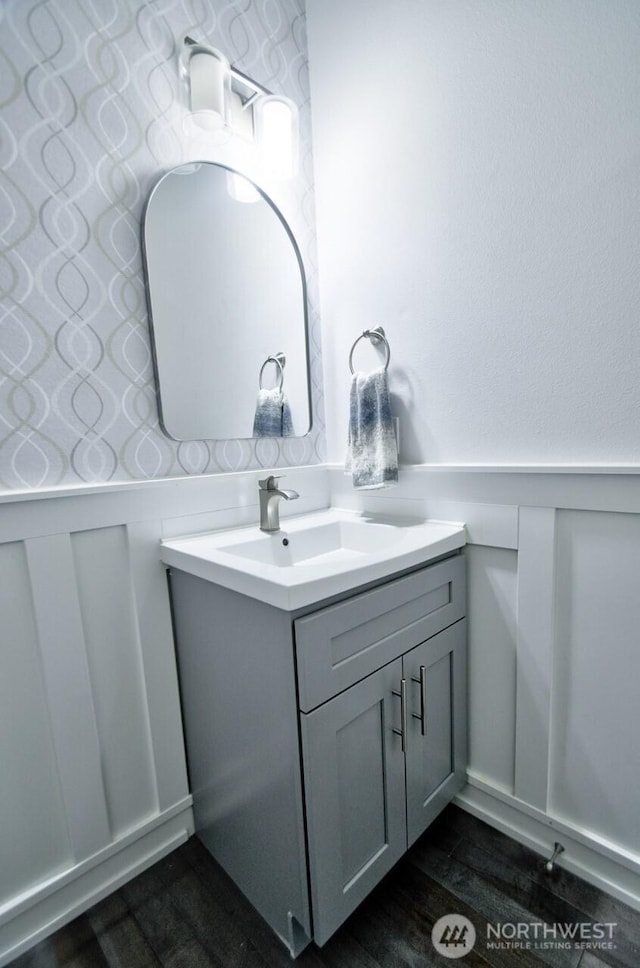 4704 204th Ct E, Spanaway, WA 98387 - bathroom with a decorative wall, vanity, a wainscoted wall, and wood finished floors