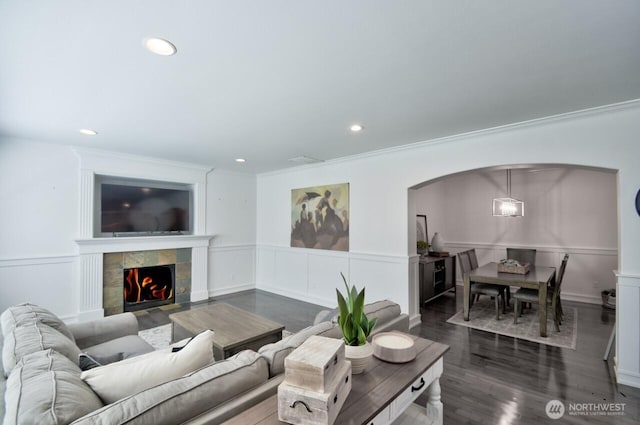 4704 204th Ct E, Spanaway, WA 98387 - living room featuring arched walkways, recessed lighting, a wainscoted wall, crown molding, and a tile fireplace