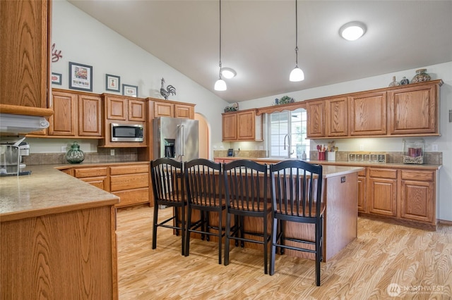 108 Garden Pl, Elma, WA 98541 - kitchen with appliances with stainless steel finishes, light wood-type flooring, lofted ceiling, and brown cabinetry