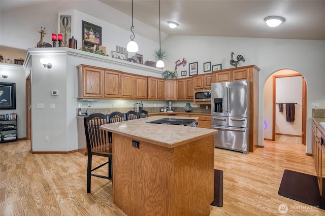 108 Garden Pl, Elma, WA 98541 - kitchen featuring stainless steel appliances, arched walkways, high vaulted ceiling, light wood-style flooring, and a breakfast bar area