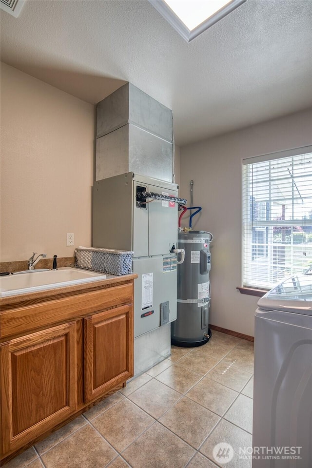 108 Garden Pl, Elma, WA 98541 - bathroom with strapped water heater, washer / dryer, a textured ceiling, tile patterned floors, and baseboards