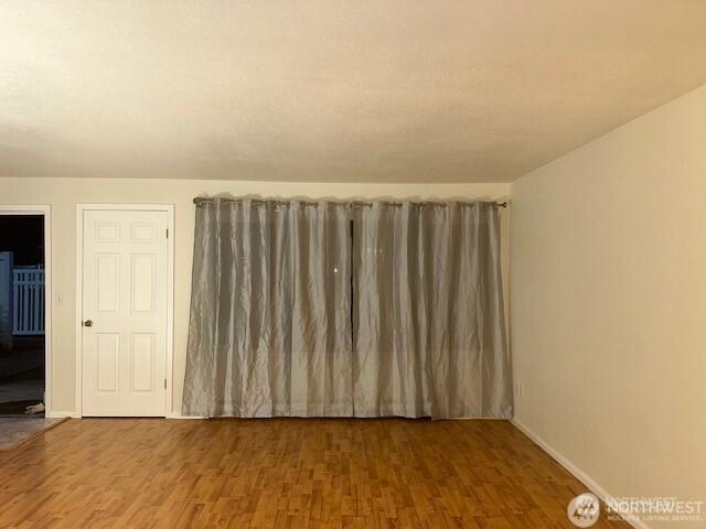 5722 122nd Pl SE Unit 235, Bellevue, WA 98006 - spare room featuring wood finished floors and baseboards