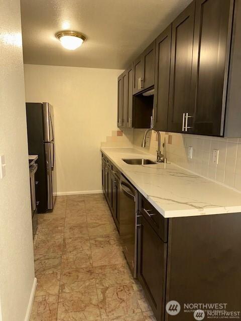 5722 122nd Pl SE Unit 235, Bellevue, WA 98006 - kitchen featuring a sink, stainless steel appliances, dark brown cabinets, baseboards, and decorative backsplash