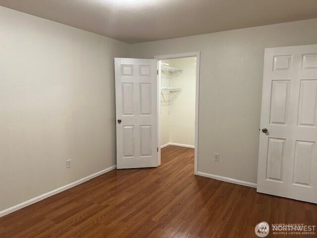5722 122nd Pl SE Unit 235, Bellevue, WA 98006 - unfurnished bedroom with a spacious closet, dark wood-style floors, baseboards, and a closet