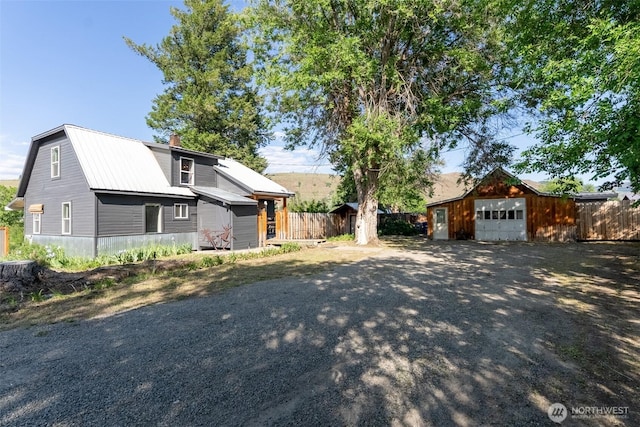 111 Norfolk Rd, Winthrop, WA 98862 - view of front of property featuring an outbuilding, driveway, a metal roof, and a chimney