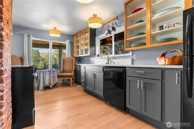 111 Norfolk Rd, Winthrop, WA 98862 - kitchen with black dishwasher, light wood-style floors, gray cabinetry, and glass insert cabinets