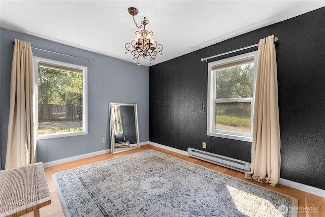 111 Norfolk Rd, Winthrop, WA 98862 - unfurnished room with a baseboard radiator, a chandelier, and wood finished floors