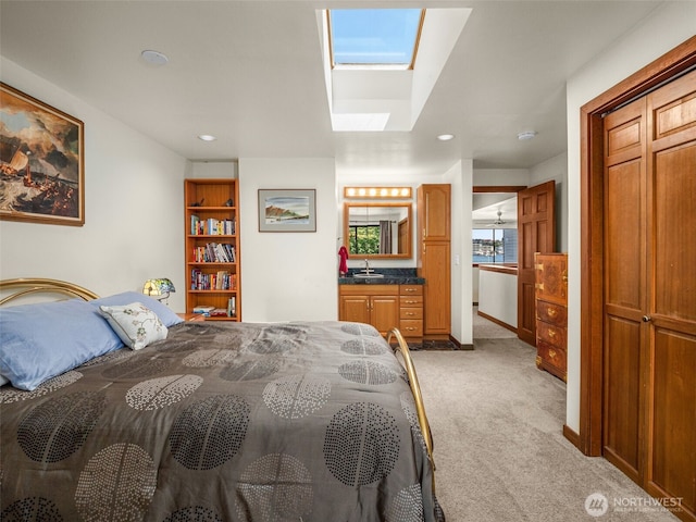 2900 Westlake Ave N, Seattle, WA 98109 - bedroom with light carpet, a skylight, a sink, recessed lighting, and baseboards