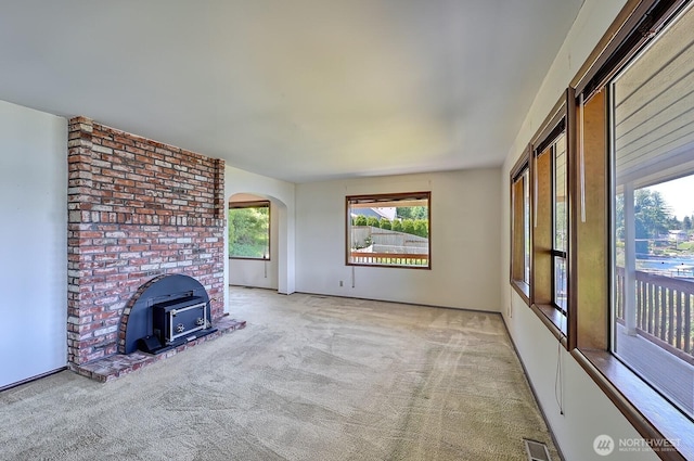 2781 Lake Whatcom Blvd, Bellingham, WA 98229 - unfurnished living room with carpet, a wood stove, and arched walkways