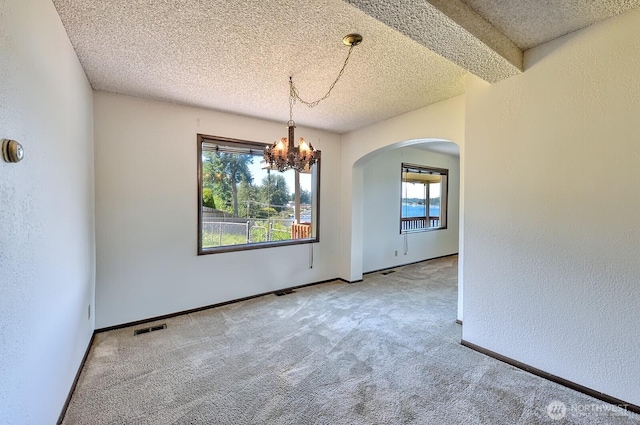 2781 Lake Whatcom Blvd, Bellingham, WA 98229 - empty room featuring arched walkways, a textured ceiling, carpet flooring, a chandelier, and a textured wall