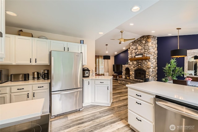 7547 NE 200 NE, Kenmore, WA 98028 - kitchen featuring stainless steel appliances, light wood-style flooring, lofted ceiling, light countertops, and a fireplace