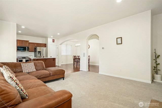 4915 NE 5th St, Renton, WA 98059 - living room featuring arched walkways, light colored carpet, recessed lighting, and baseboards