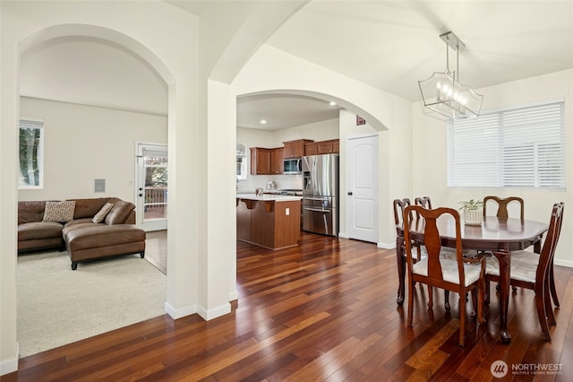 4915 NE 5th St, Renton, WA 98059 - dining area with arched walkways, dark wood finished floors, baseboards, and a chandelier