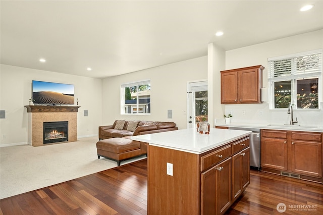 4915 NE 5th St, Renton, WA 98059 - kitchen with a sink, dark wood-style floors, a kitchen island, light countertops, and a tiled fireplace