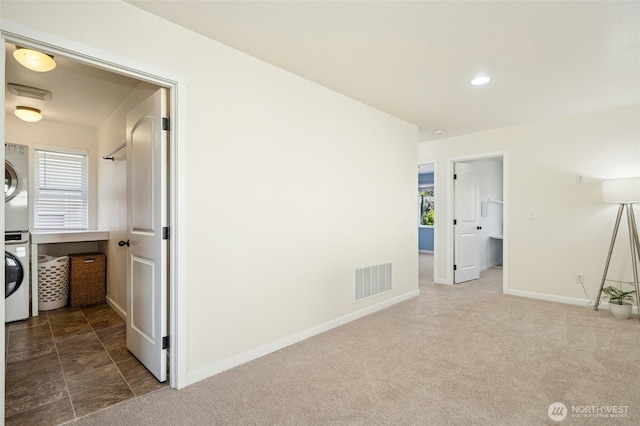 4915 NE 5th St, Renton, WA 98059 - spare room with stacked washer / dryer, plenty of natural light, dark colored carpet, baseboards, and recessed lighting