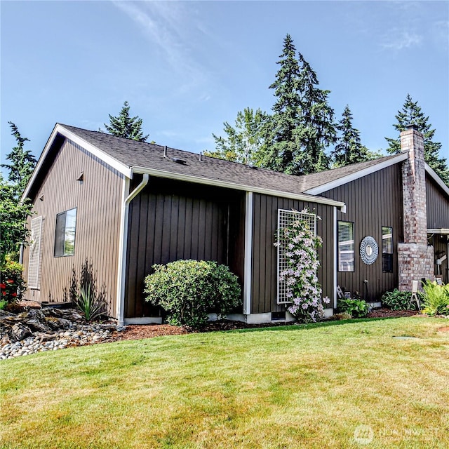 4425 65th St E, Tacoma, WA 98443 - view of home's exterior featuring a yard, a shingled roof, and a chimney