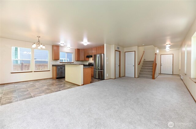 2413 106th Dr SE, Lake Stevens, WA 98258 - kitchen with appliances with stainless steel finishes, a chandelier, light colored carpet, a kitchen island, and open floor plan