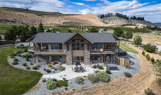 24386 US Highway 97, Chelan, WA 98816 - back of house featuring a patio area, a deck with mountain view, a jacuzzi, stone siding, and a sunroom