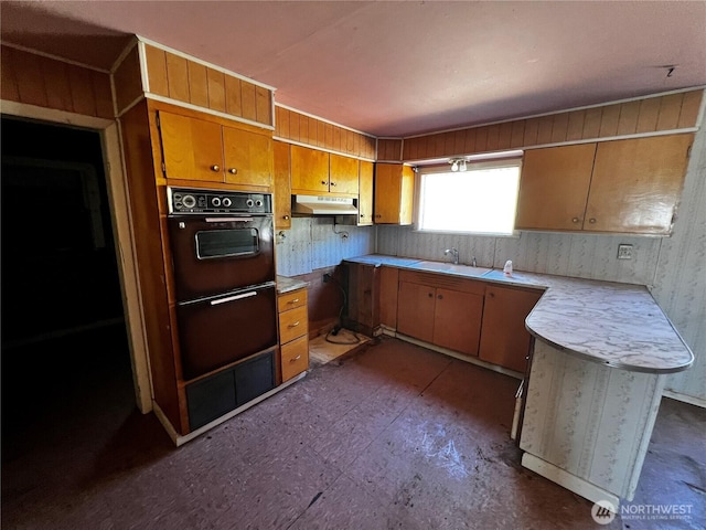 2405 Elmway, Okanogan, WA 98840 - kitchen featuring under cabinet range hood, light countertops, a sink, brown cabinets, and double wall oven